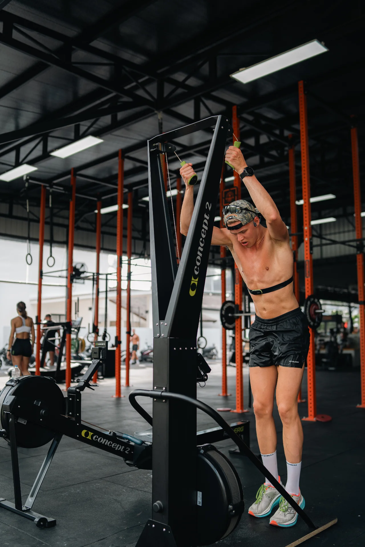 מתאמן על מכשיר חתירה ומתקני כוח במתחם Samui Fitness Lab